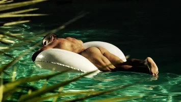 2291-rearview-floating-naked-in-a-pool.webp